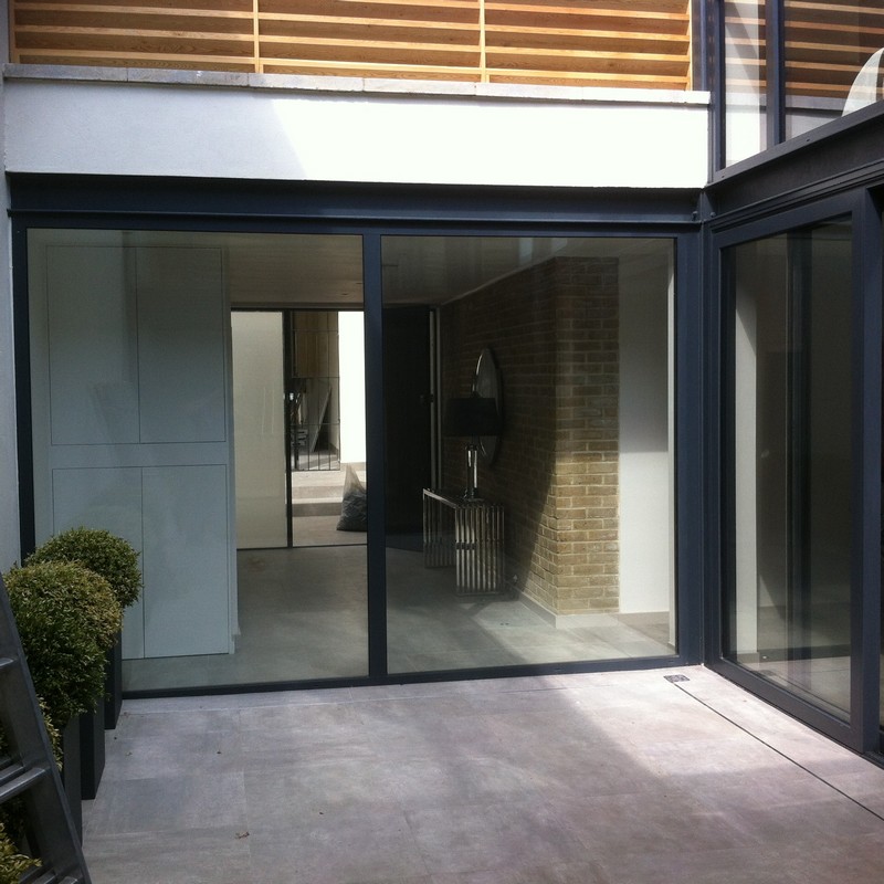Floor-to-ceiling sliding doors opening to courtyard in Pinner